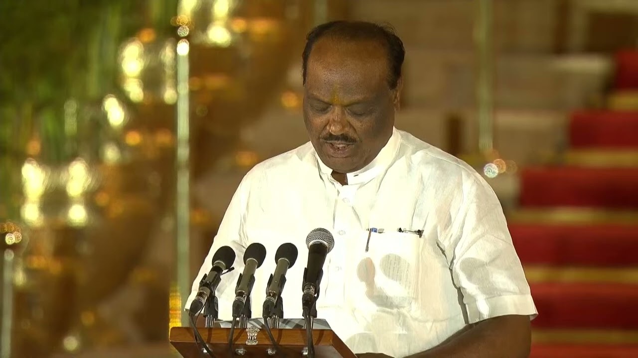 Durga Das Uikey reading the oath of office at a lectern with microphones at Rashtrapati Bhavan